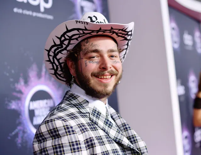 Post Malone smiling at a public event